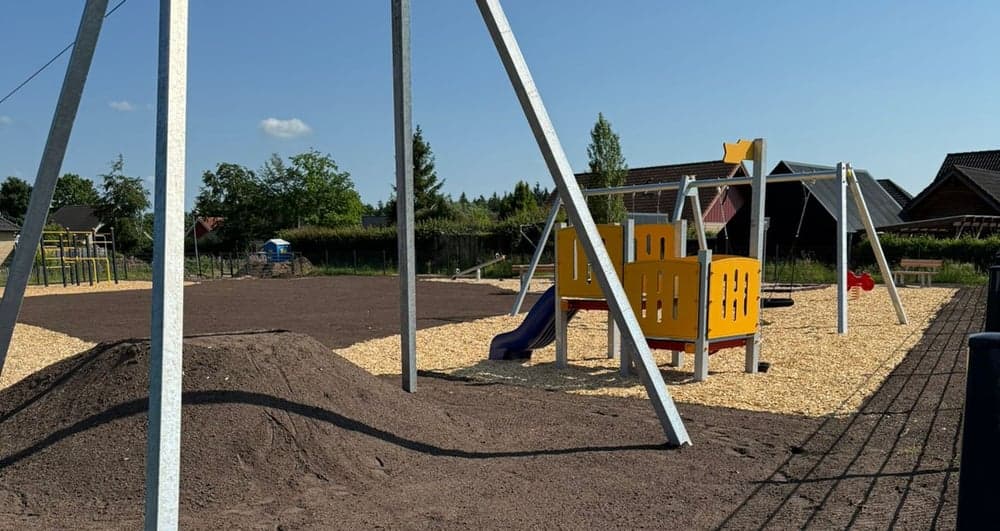Spielbereich mit Schaukel und Rutsche auf dem Spielplatz am Langbarg.